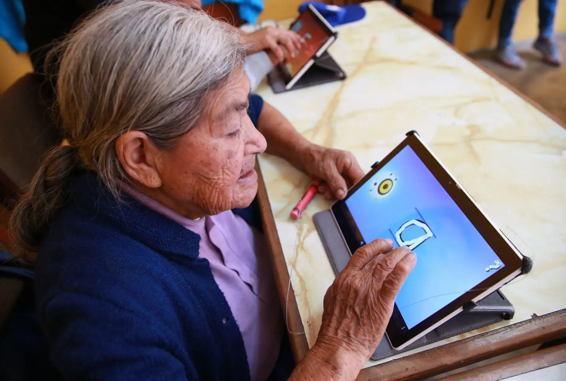 Abuelos quechua-hablantes del distrito de El Agustino aprenden a leer, escribir en español mediante el uso de tablets facilitadas por voluntaria de Telefónica del Perú. Foto: ANDINA/ Norman Córdova