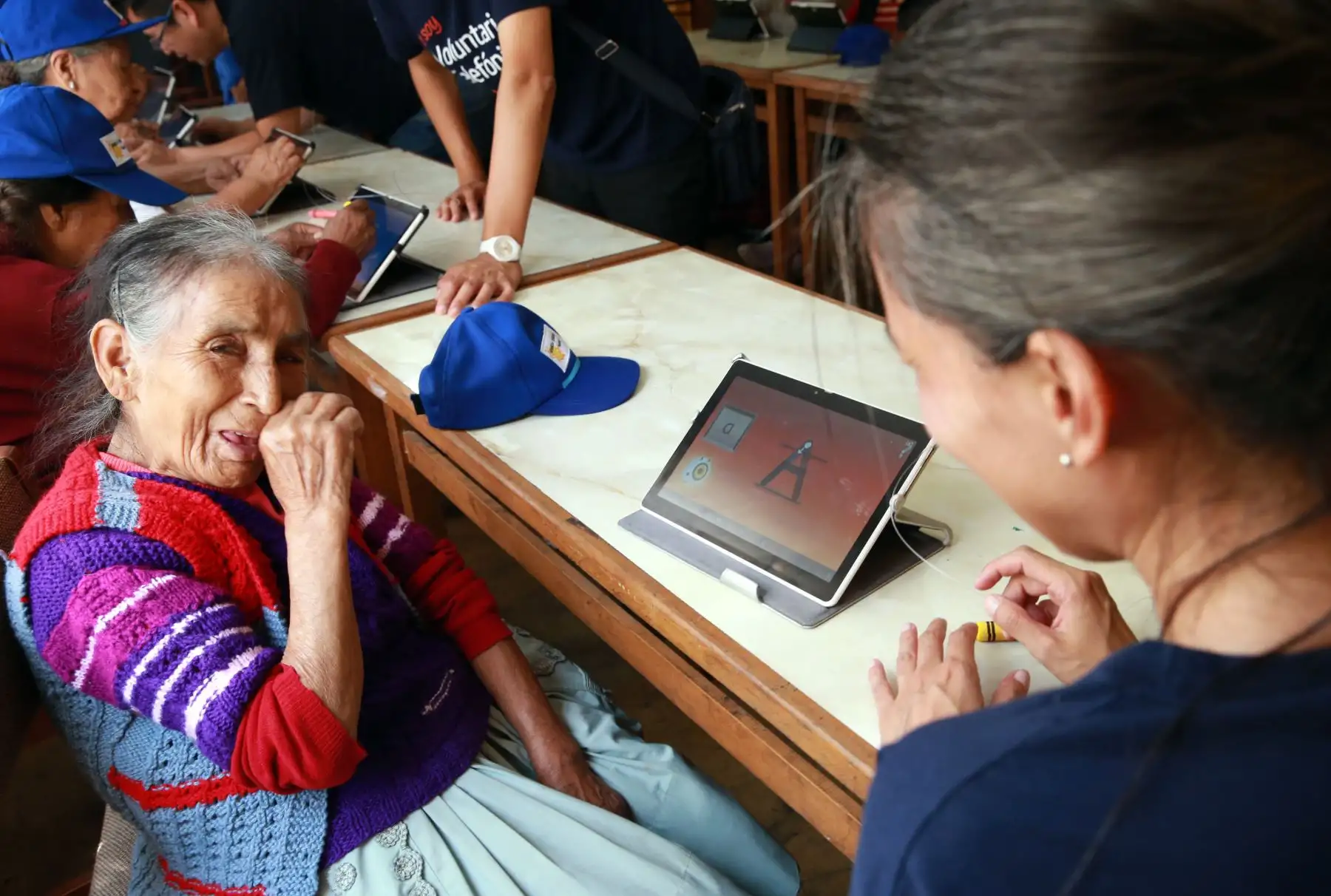 Abuelos quechua-hablantes del distrito de El Agustino aprenden a leer, escribir en español mediante el uso de tablets facilitadas por voluntaria de Telefónica del Perú. Foto: ANDINA/ Norman Córdova