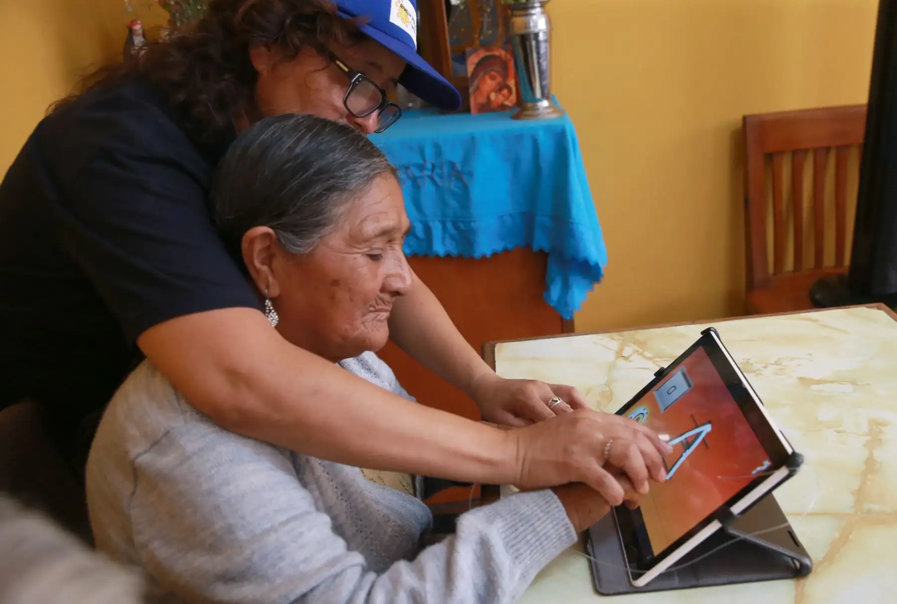 Abuelos quechua-hablantes del distrito de El Agustino aprenden a leer, escribir en español mediante el uso de tablets facilitadas por voluntaria de Telefónica del Perú. Foto: ANDINA/ Norman Córdova
