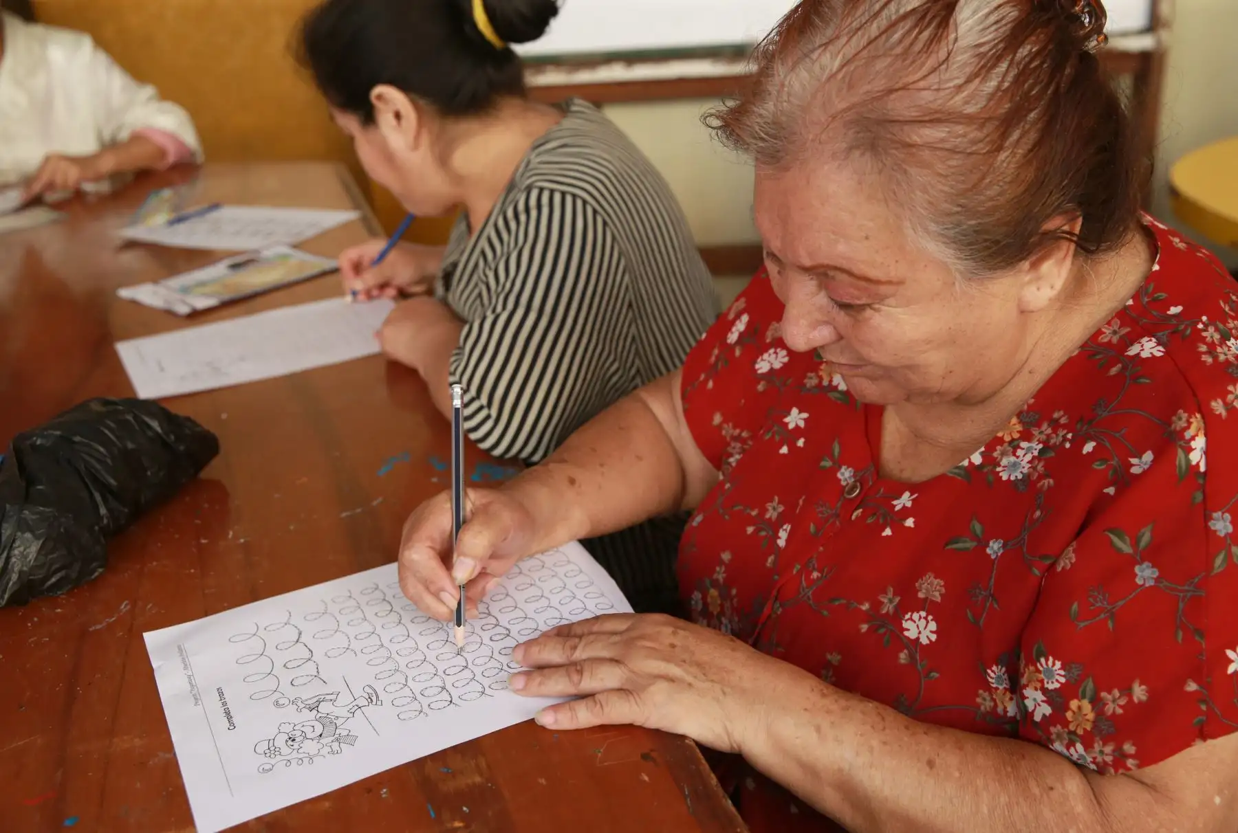 Abuelos quechua-hablantes del distrito de El Agustino aprenden a leer, escribir en español mediante el uso de tablets facilitadas por voluntaria de Telefónica del Perú. Foto: ANDINA/ Norman Córdova