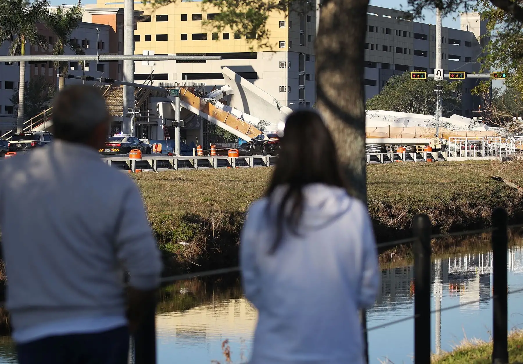 Personas miran el puente peatonal que colapsó unos días después de que se construyó en Miami, Florida. Foto: AFP