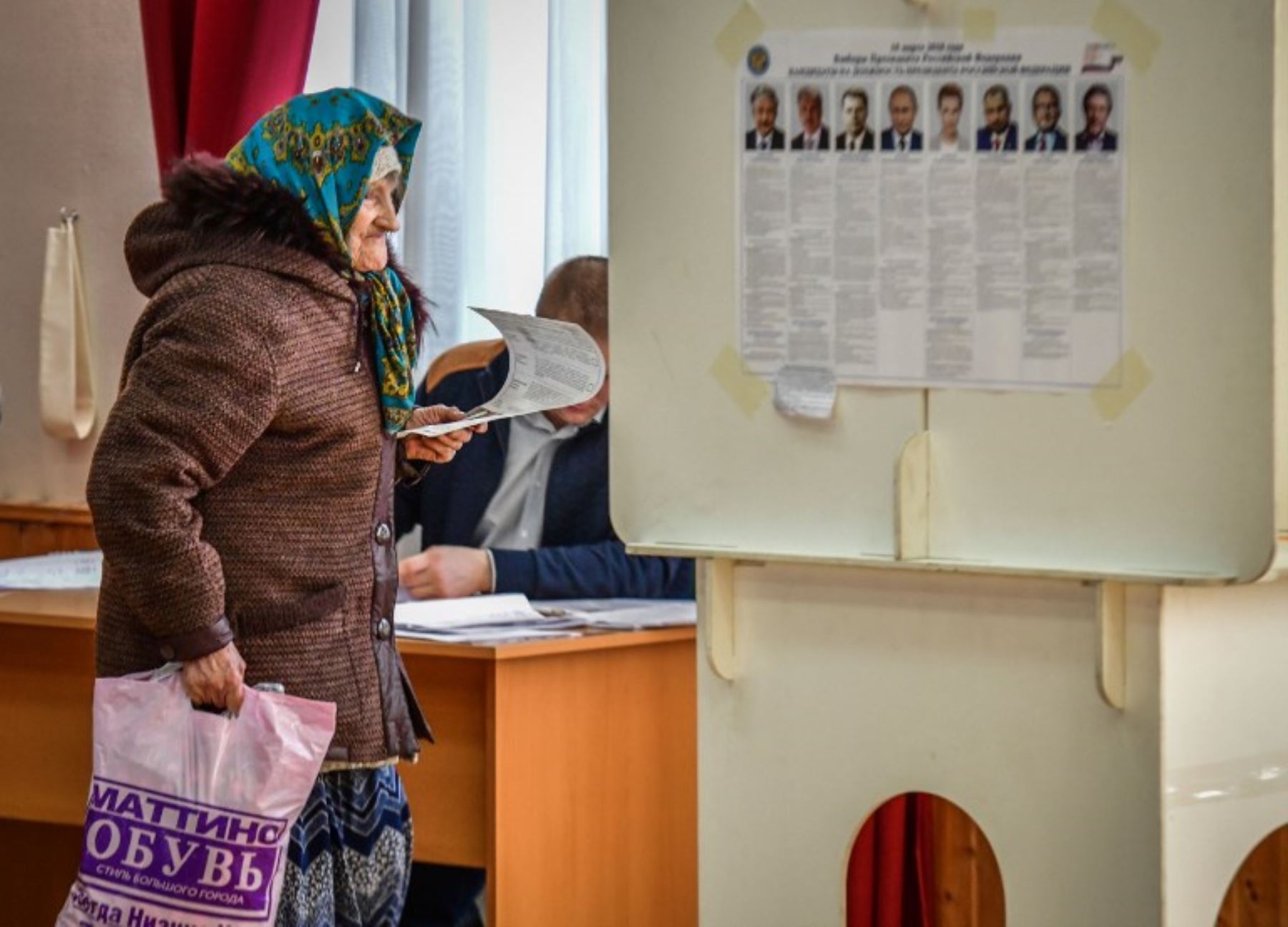 Una anciana camina con su voto en una mesa de votación durante las elecciones presidenciales de Rusia.Foto:AFP