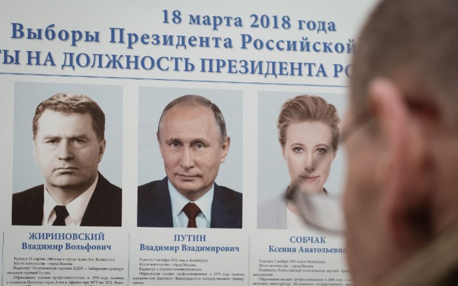 Una persona mira un cartel que muestra los candidatos presidenciales en un colegio electoral en la embajada rusa en Minsk durante las elecciones presidenciales de Rusia.Foto:AFP