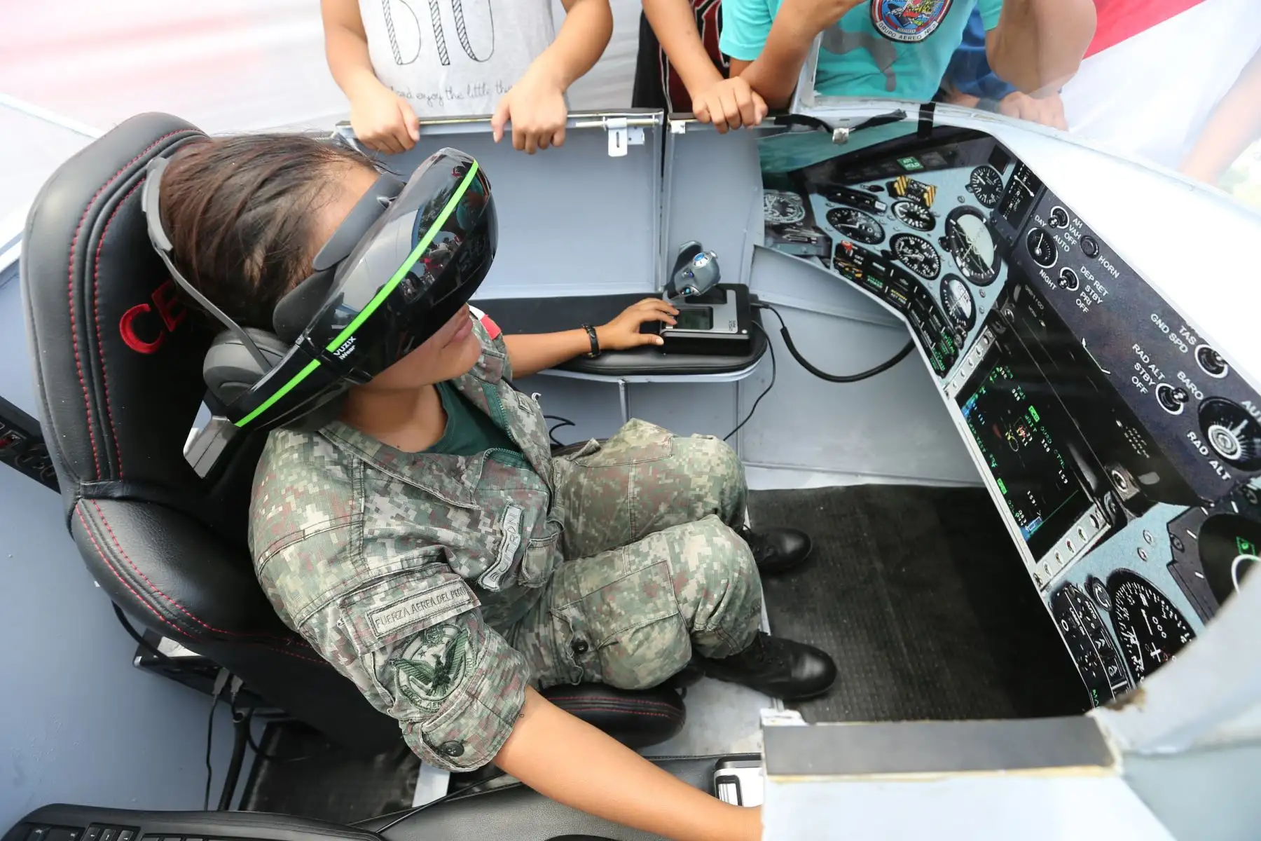 El público disfrutó de una exhibición de diferentes modelos de aviones militares que sobrevolaron el circuito de playas de la Costa Verde, durante el Primer Festival Aerodeportivo “Costa Verde 2018”.  En la foto, una asistente prueba un  moderno simulador de vuelo. Foto: ANDINA/Norman Córdova