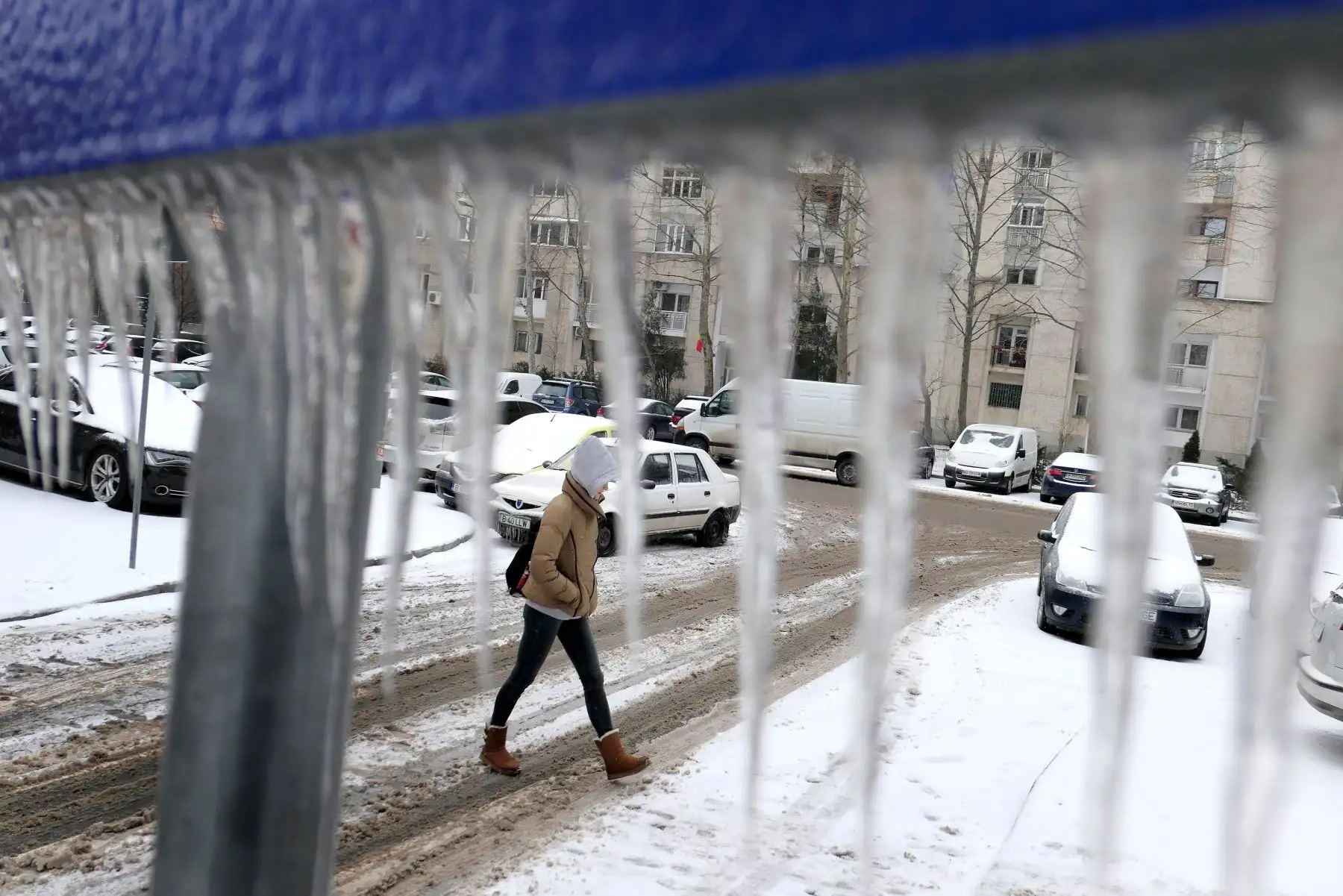 Foto: EFE Una mujer cruza junto a una señal congelada, en Bucarest, Rumanía. EFE/ Robert Ghement
