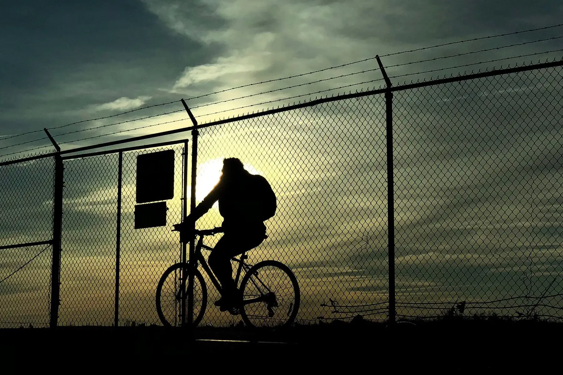 Un ciclista pasa junto a la valla del perímetro del Aeropuerto Nacional Reagan durante el amanecer en Alexandria, estado de Virgina (Estados Unidos). Se espera que las temperaturas alcancen los 13º en Washington, pero durante los próximos dos días se experimentará una tormenta de nieve, la cuarta en las últimas dos semanas, coincidente con el primer día de primavera. EFE/ Matt Campbell