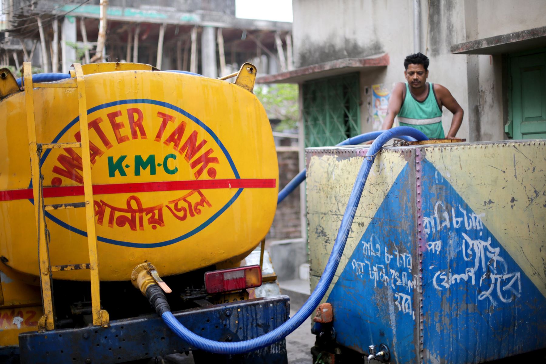 Un trabajador maneja el tanque contenedor municipal en el Día Mundial del Agua en un barrio pobre de Calcuta (India).