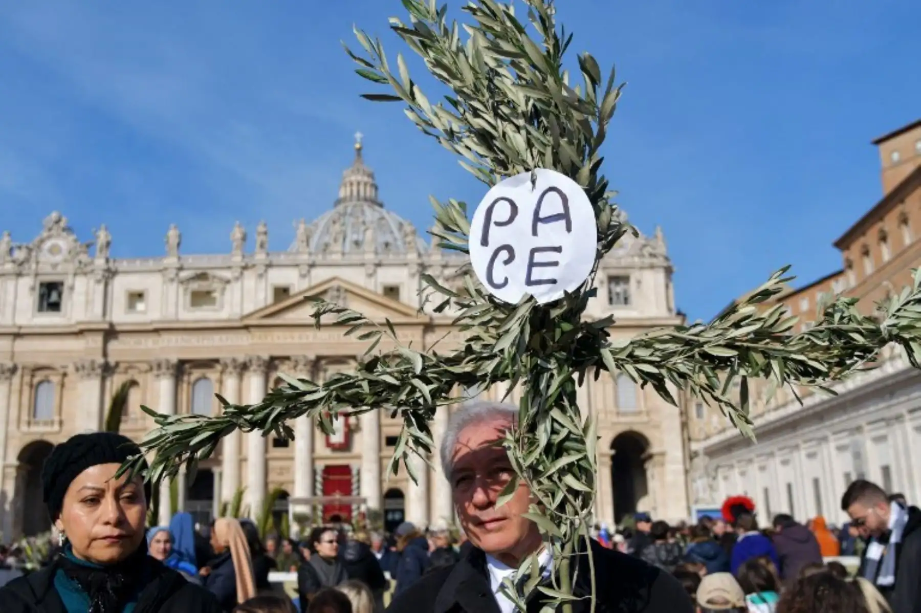 Un fiel sosteniendo una cruz hecha con ramas de olivo con la paz mundial durante la misa del Domingo de Ramos en la plaza de San Pedro en el Vaticano.Foto:AFP