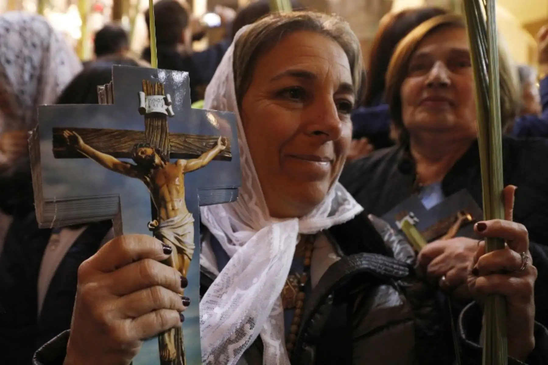Una peregrina católica romano sostiene una palmera y una imagen de Jesús durante la procesión del Domingo de Ramos en la Iglesia del Santo Sepulcro en la Ciudad Vieja de Jerusalén.Foto:AFP