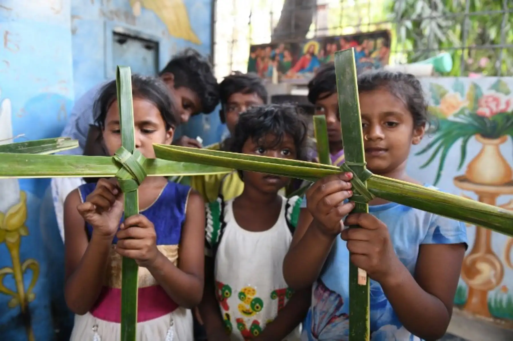 Los niños cristianos en la India sostienen cruces hechas de hojas de palmera durante un servicio del Domingo de Ramos en Hyderabad.Foto:AFP