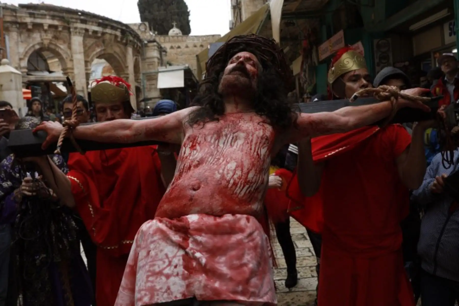Un peregrino católico está atado a una cruz mientras recrea la pasión de Jesucristo en la Vía Dolorosa en la Ciudad Vieja de Jerusalén durante la procesión del Viernes Santo.Foto:AFP