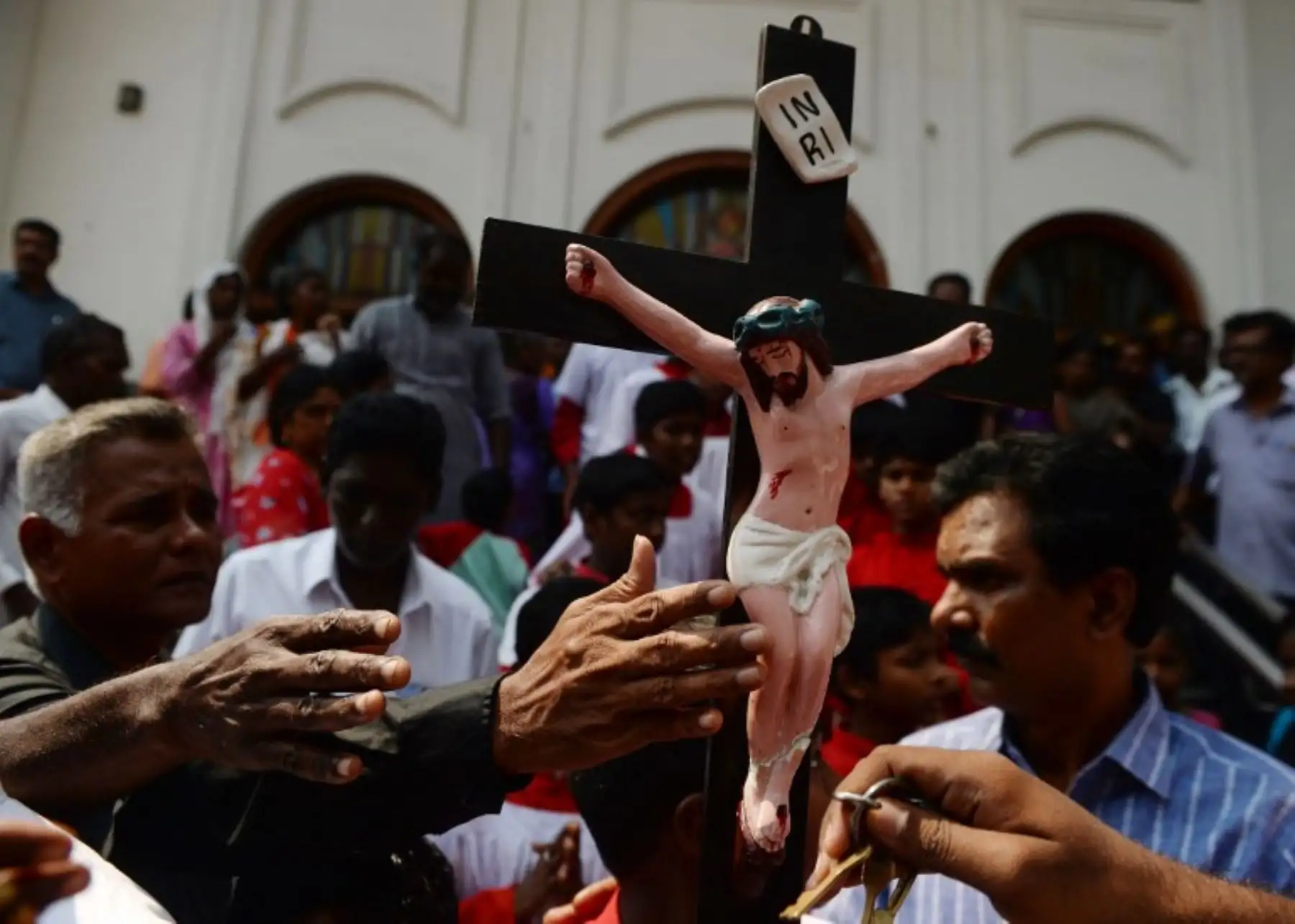 Los católicos indios se acercan a una cruz mientras participan en una procesión para representar nuevamente la crucifixión de Jesucristo el Viernes Santo en Chennai