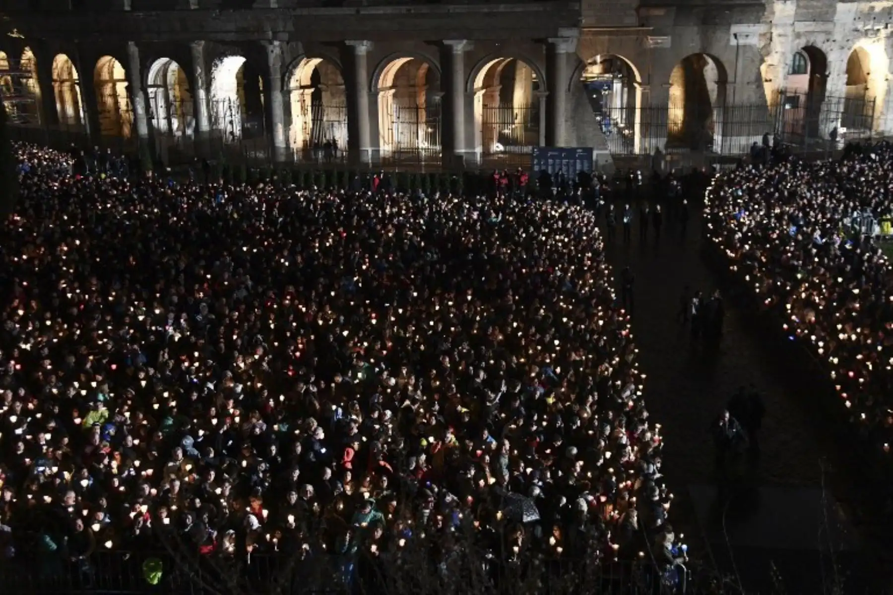 Fieles se reúnen en el antiguo Coliseo para la procesión de antorchas del vía crucis, del Viernes Santo, en Roma. Foto: AFP.