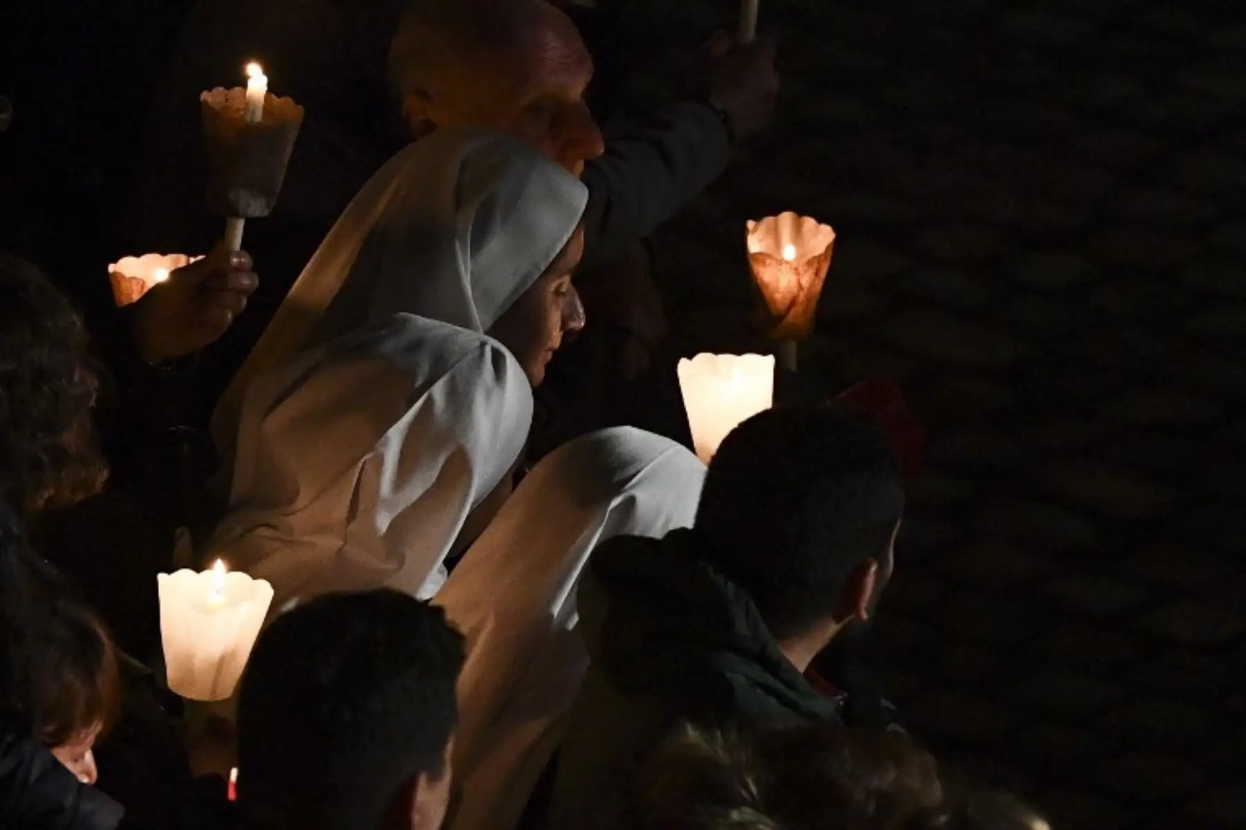Fieles se reúnen en el antiguo Coliseo para la procesión de antorchas del vía crucis, del Viernes Santo, en Roma. Foto: AFP.
