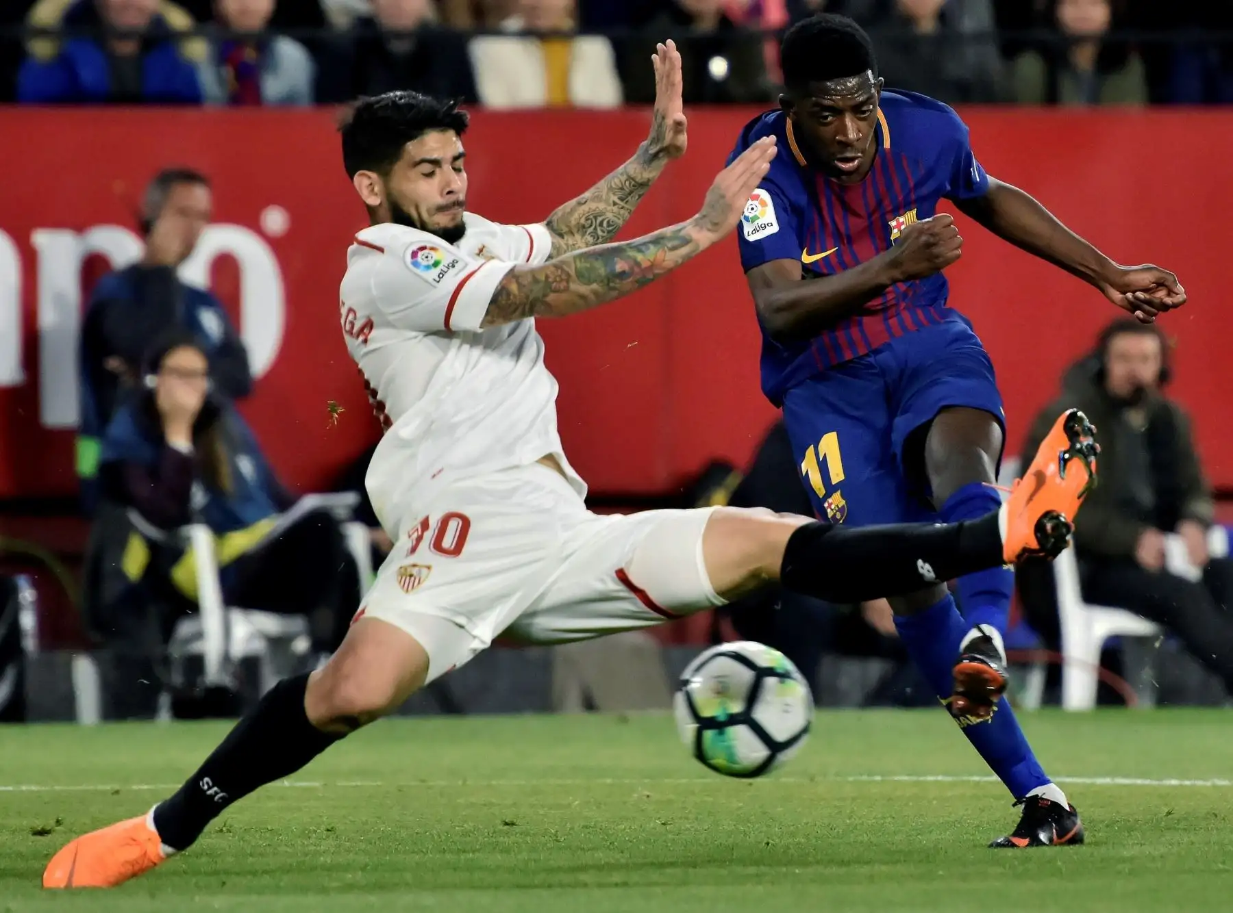 El delantero del FC Barcelona Dembelé, lucha  el balón ante Banega, del Sevilla, durante el partido de la trigésima jornada de Liga en Primera División.Foto:EFE