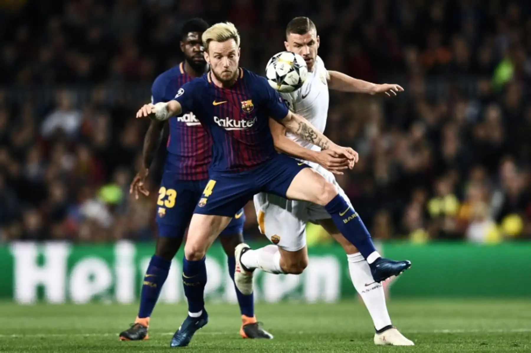 El delantero bosnio ucraniano Edin Dzeko desafía al mediocampista croata Ivan Rakitic y al defensor francés Samuel Umtiti (vuelta), durante el partido de ida de cuartos de final de la UEFA Champions League entre el Barcelona y la AS Roma. Foto: AFP.