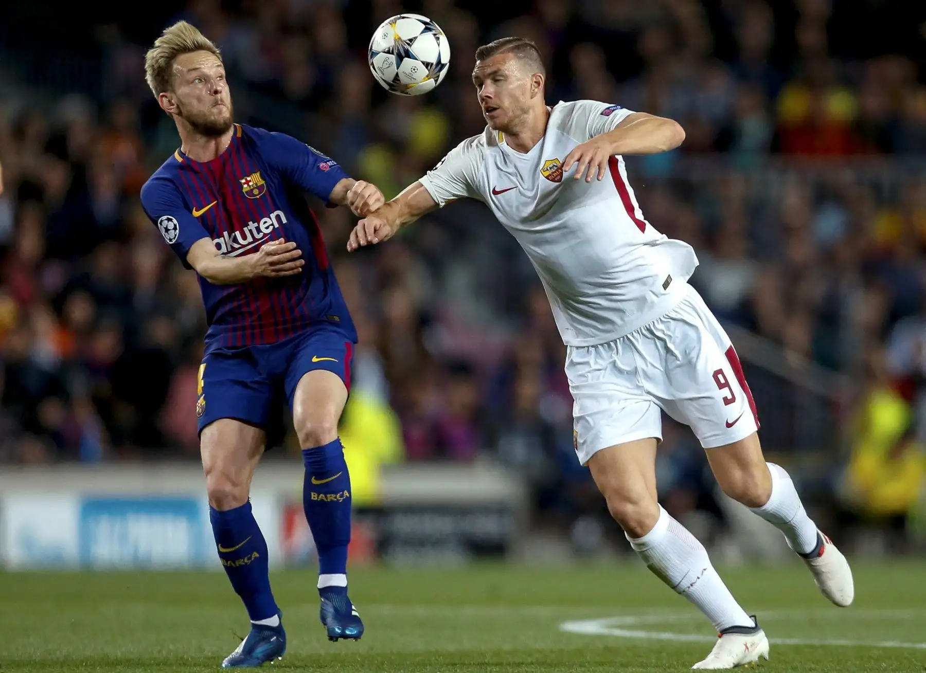 El centrocampista croata del Barcelona Ivan Rakitic pelea un balón con el delantero bosnio del Roma Edin Dzeko, durante el partido de ida de cuartos de final de la Liga de Campeones. Foto: EFE.