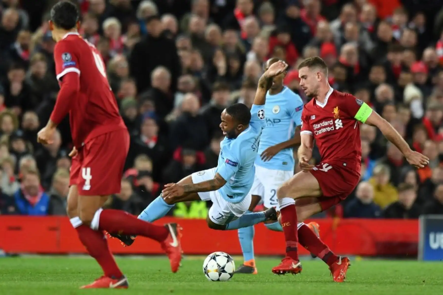 El centrocampista inglés del Manchester City Raheem Sterling compite con el centrocampista inglés del Liverpool Jordan Henderson, durante el partido de fútbol de cuartos de final de la UEFA Champions League entre Liverpool y Manchester City. Foto: AFP.