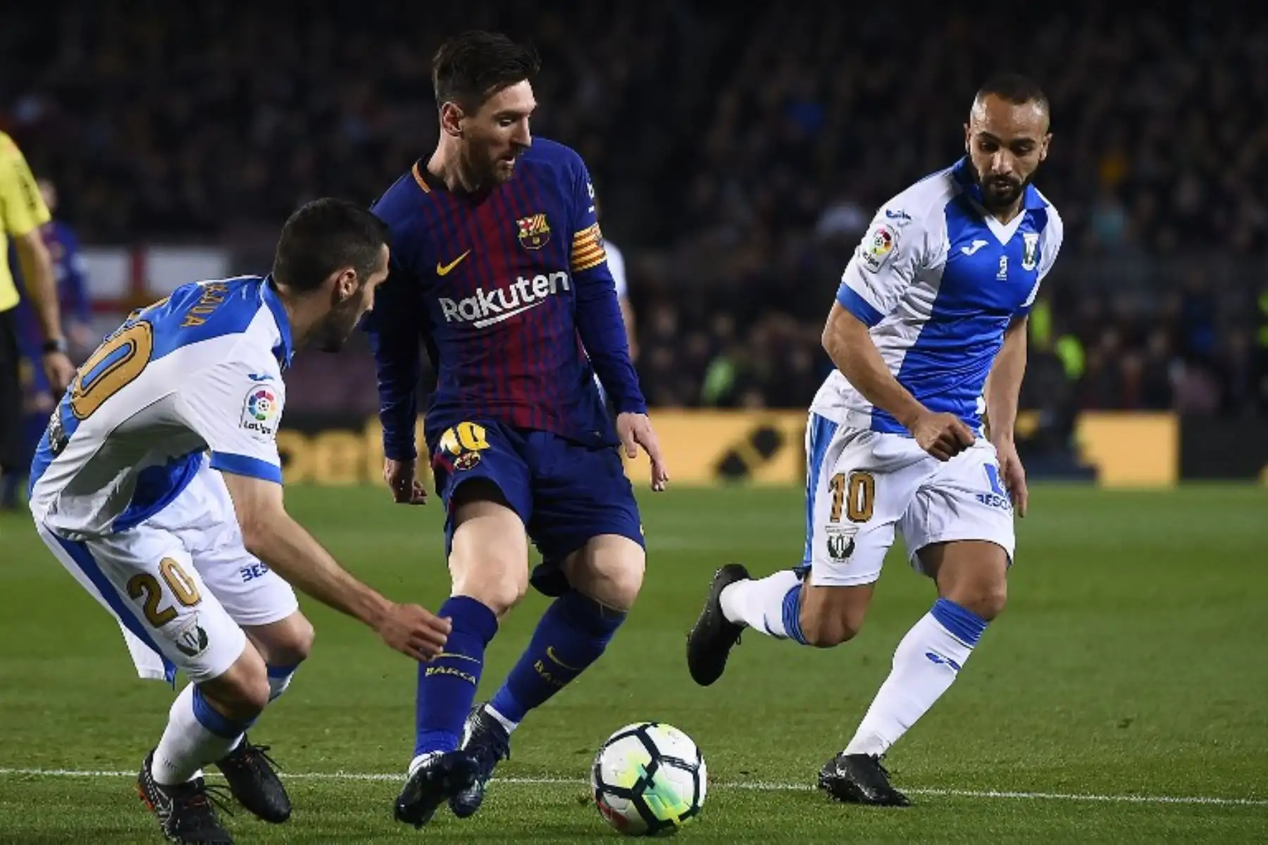 Lionel Messi reta al delantero marroquí de Leganes Nabil El Zhar y al defensa español de Leganes Joseba Zaldua, durante el partido de fútbol de la liga española entre Barcelona y Leganés.Foto:AFP