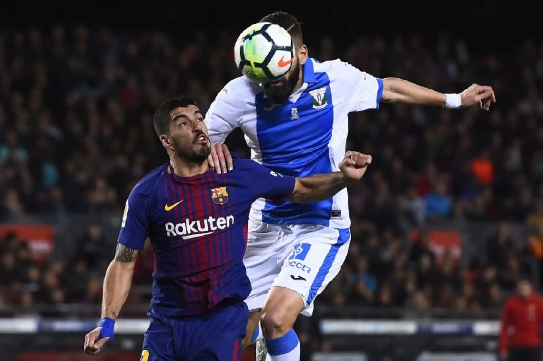 El defensa griego de Leganes Dimitrios Siovas encabeza el balón junto al delantero uruguayo del Barcelona Luis Suárez durante el partido de fútbol de la liga española entre Barcelona y Leganés.Foto:AFP