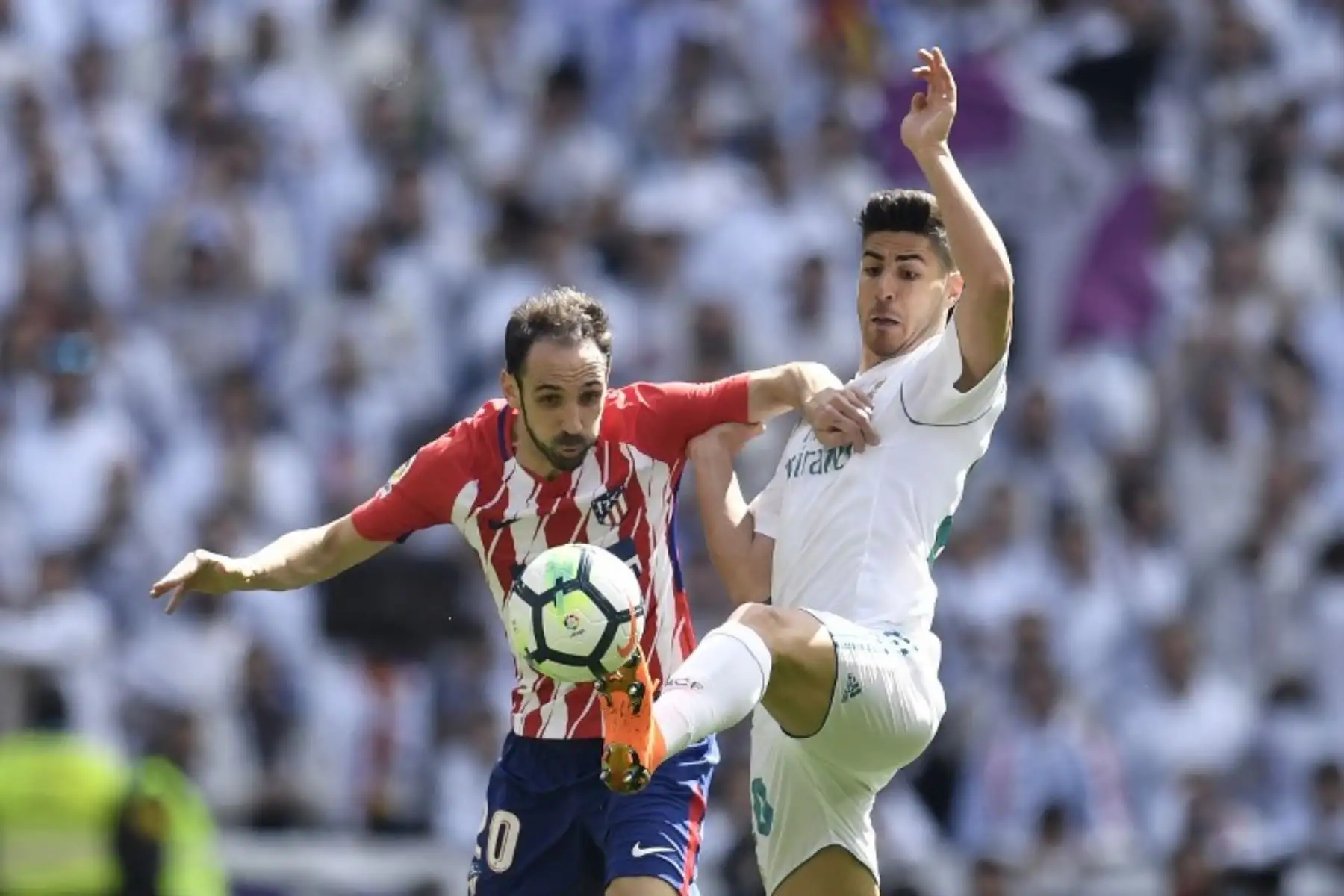 El centrocampista español del Real Madrid Marco Asensio (R) desafía al defensa español del Atlético de Madrid Juanfran durante el partido de fútbol de la liga española .Foto:AFP