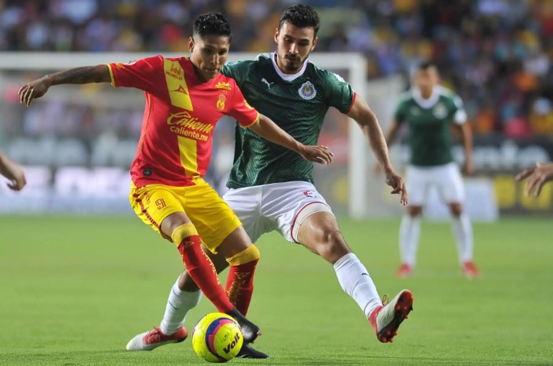 Raúl Ruidiaz de Morelia compite por el balón con Oswaldo Alanis, de Guadalajara durante su partido de fútbol del torneo Clausura mexicano .Foto: AFP