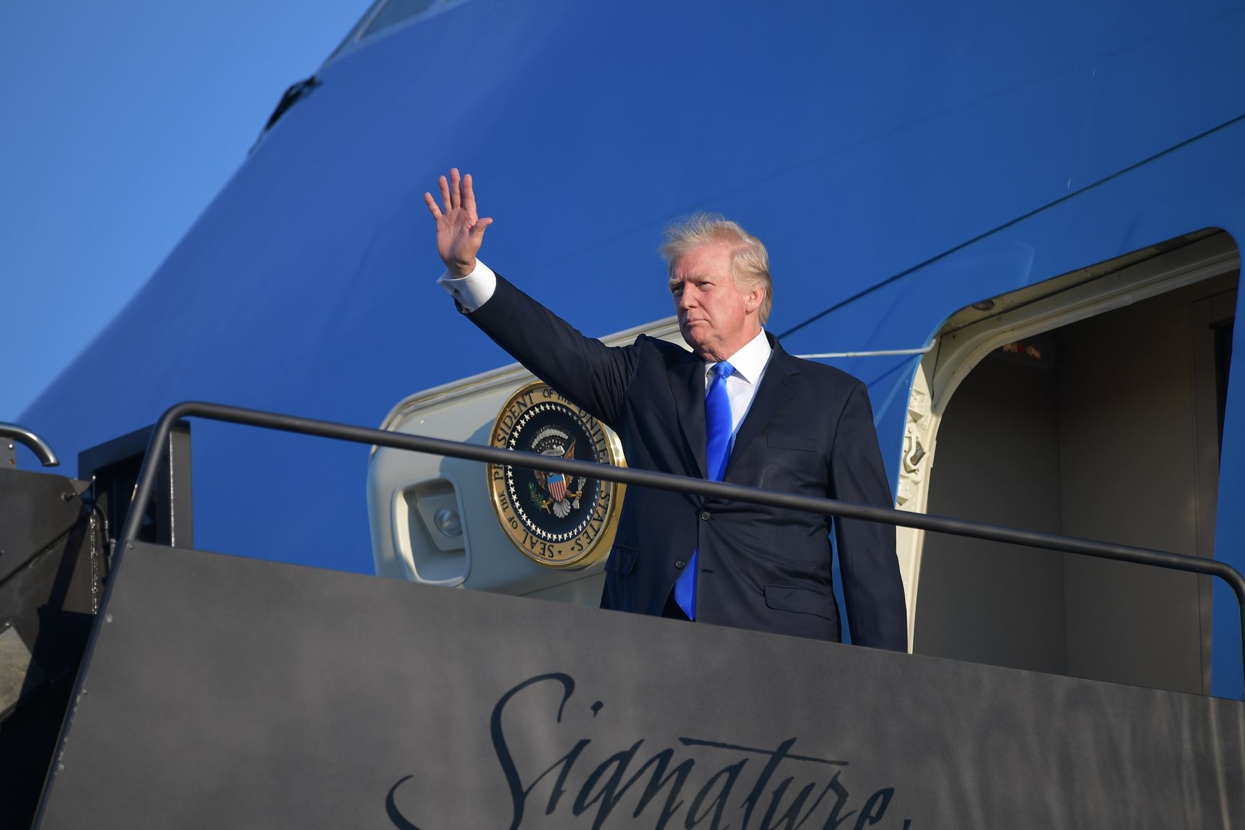El presidente de EE. UU Donald Trump, saluda a bordo del Air Force One antes de partir desde el aeropuerto Liberty de Newark en Newark, Nueva Jersey, el 11 de junio de 2017. Foto: AFP