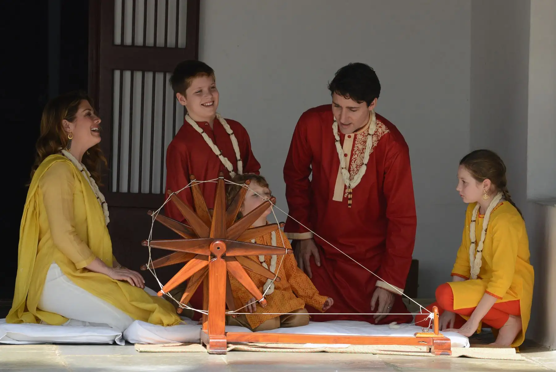 El primer ministro canadiense Justin Trudeau y su familia prueban una rueda ceremonial durante su visita a Gandhi Ashram en la India. Foto: AFP