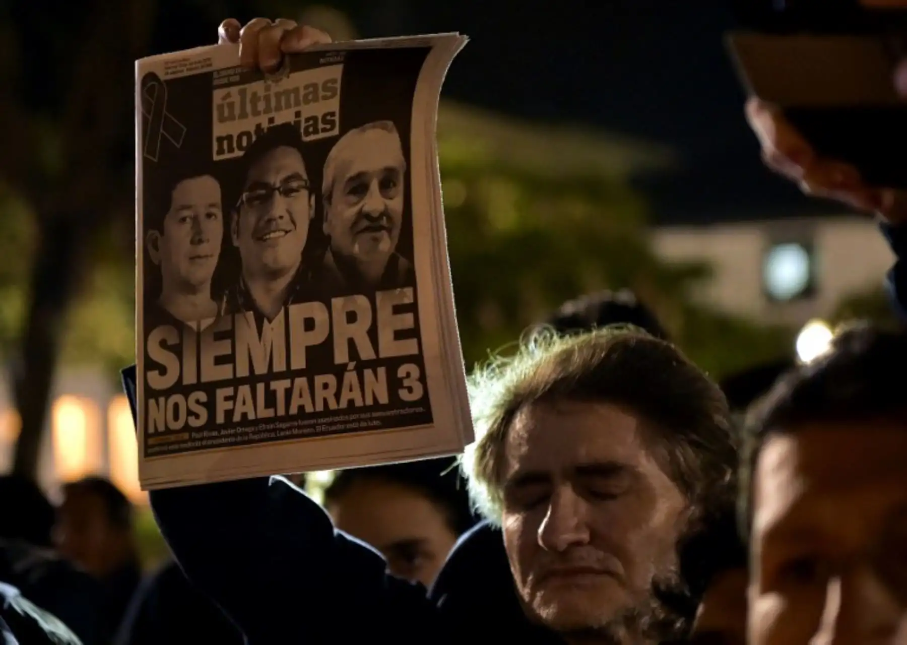 Un hombre sostiene un periódico durante un homenaje al periodista asesinado ecuatoriano Javier Ortega, el fotógrafo Paul Rivas y su chofer Efraín Segarra, frente a la Catedral Metropolitana.Foto:AFP
