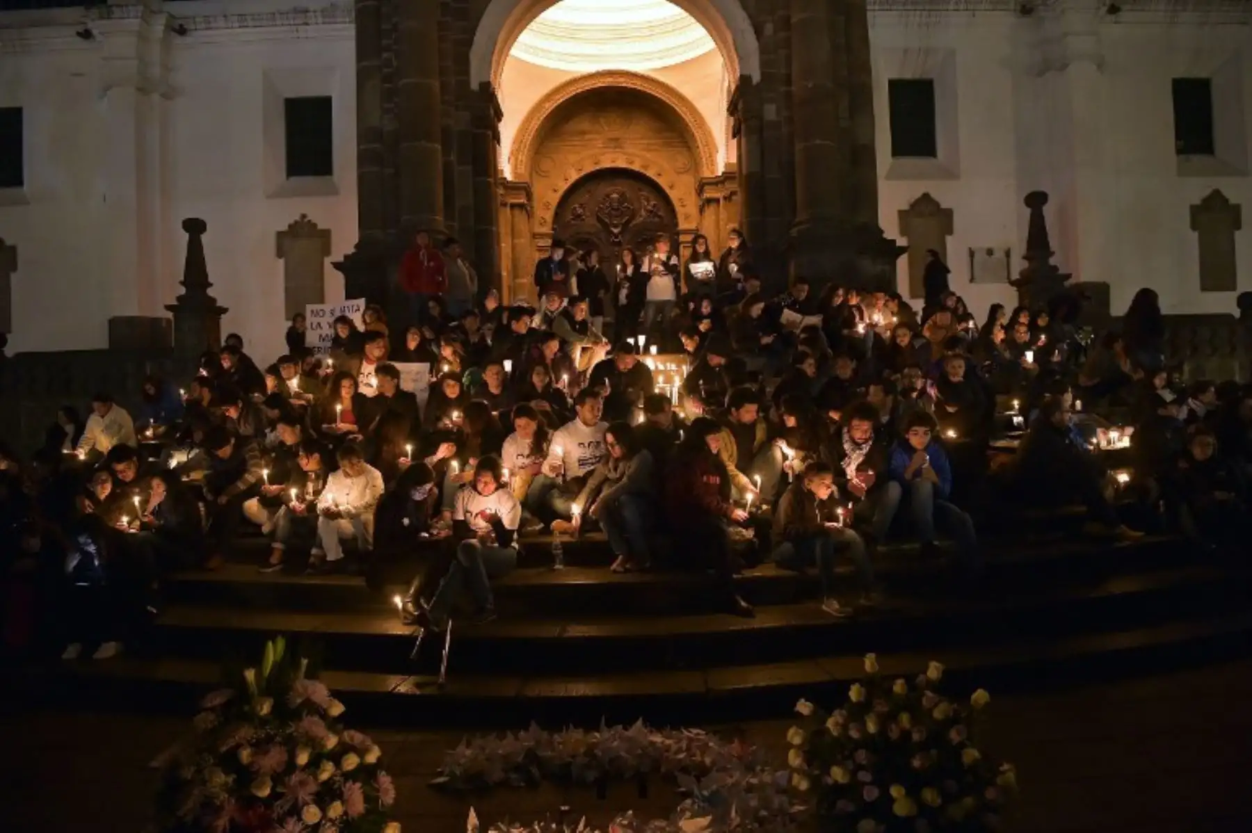 Amigos y familiares del periodista asesinado ecuatoriano Javier Ortega, el fotógrafo Paul Rivas y su chofer Efraín Segarra, encienden velas y rezan frente a la Catedral Metropolitana, en Quito.Foto:AFP