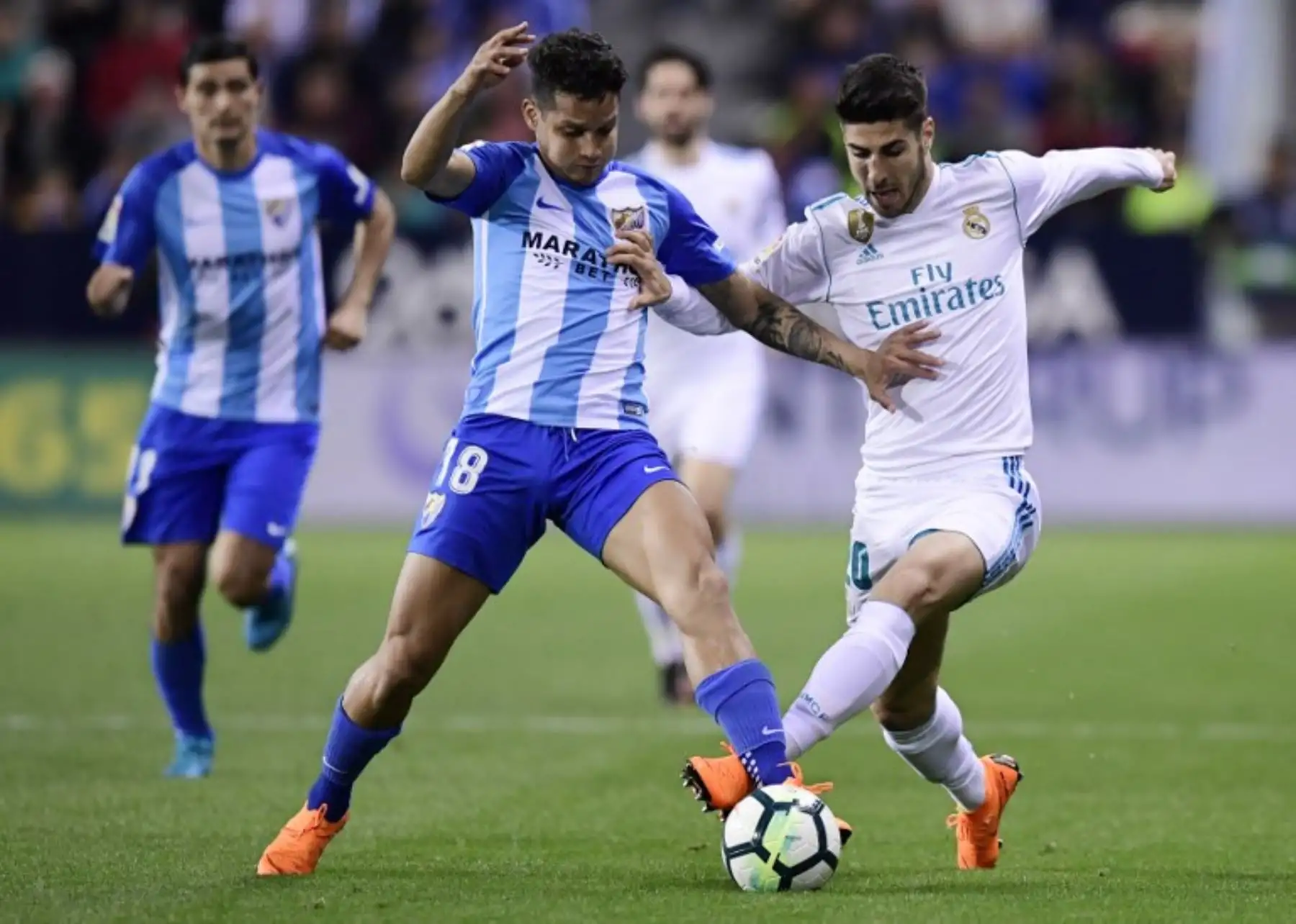 El defensor venezolano del Málaga Roberto Rosales VIES CON el centrocampista español del Real Madrid Marco Asensio durante el partido de fútbol de la liga española.Foto:AFP