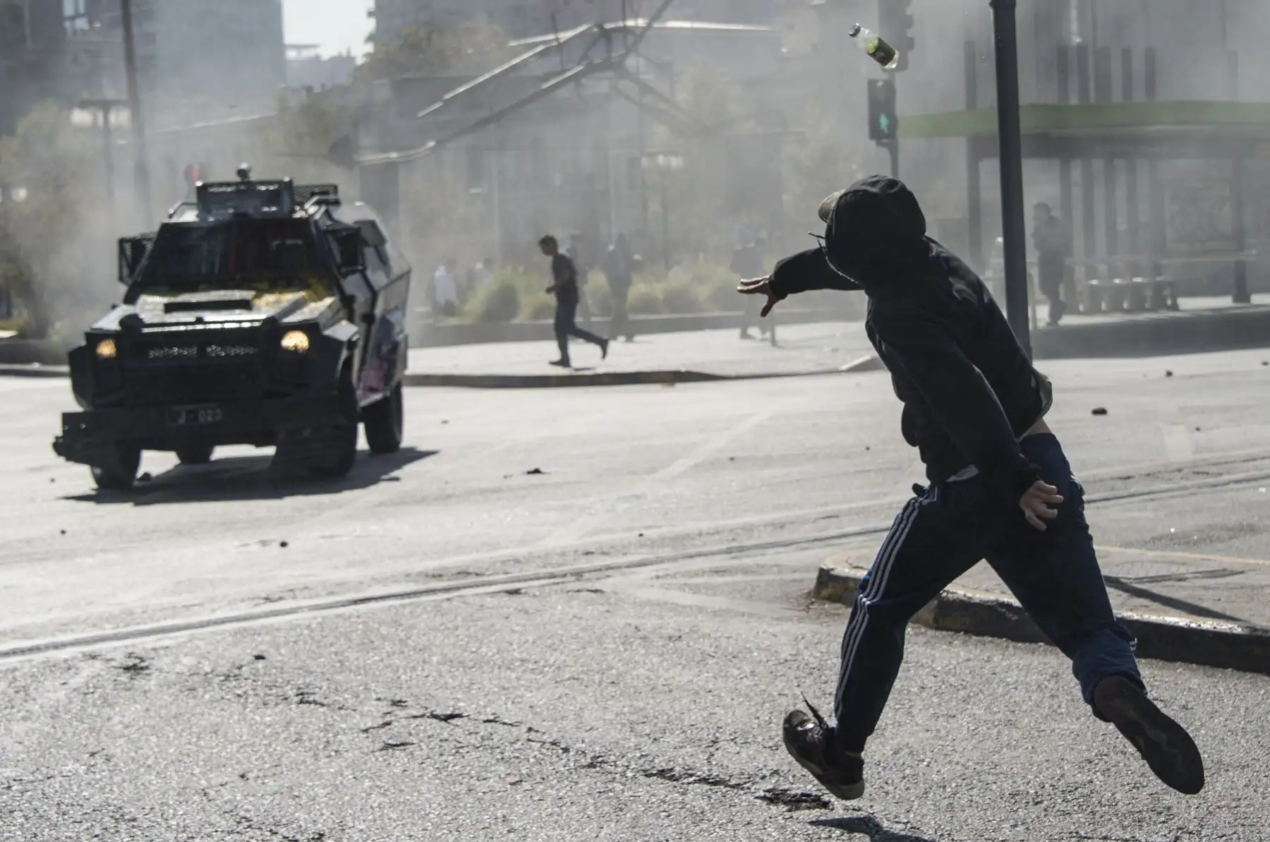 Estudiante lanza una piedra a la policía antidisturbios durante la protestan contra la lentitud en el progreso de la reforma educativa chilena, en Santiago. AFP