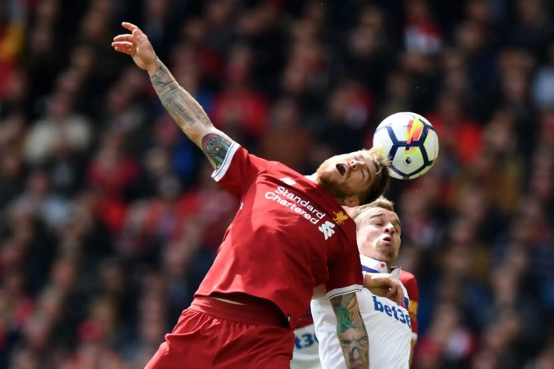 El español del Liverpool Alberto Moreno encabeza el balón más allá del delantero inglés Stoke City Peter Crouch durante el partido de fútbol de la Premier League inglesa.Foto:AFP