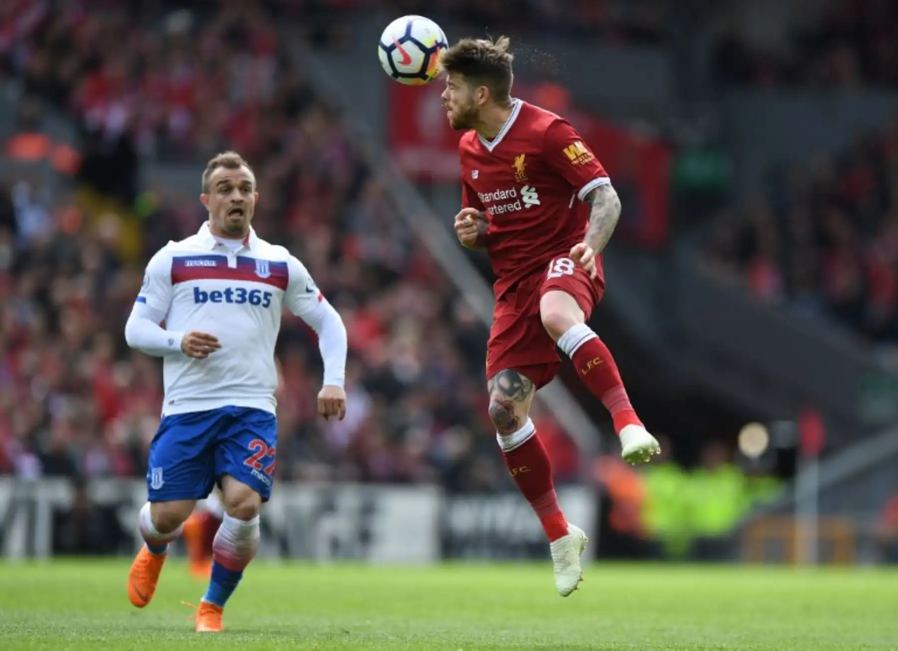 El despañol del Liverpool Alberto Moreno  encabeza la pelota pasando al suizo de Stoke City Xherdan Shaqiri durante el partido de fútbol de la Premier League inglesa.FotoAFP