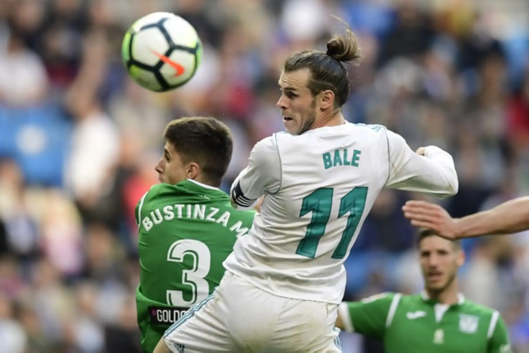 El galés del Real Madrid Gareth Bale encabeza la pelota con el defensa español de Leganés Unai Bustinza durante el partido de fútbol de la Liga española entre Real Madrid y Leganés en el estadio Santiago Bernabéu de Madrid el 28 de abril de 2018.Foto:AFP