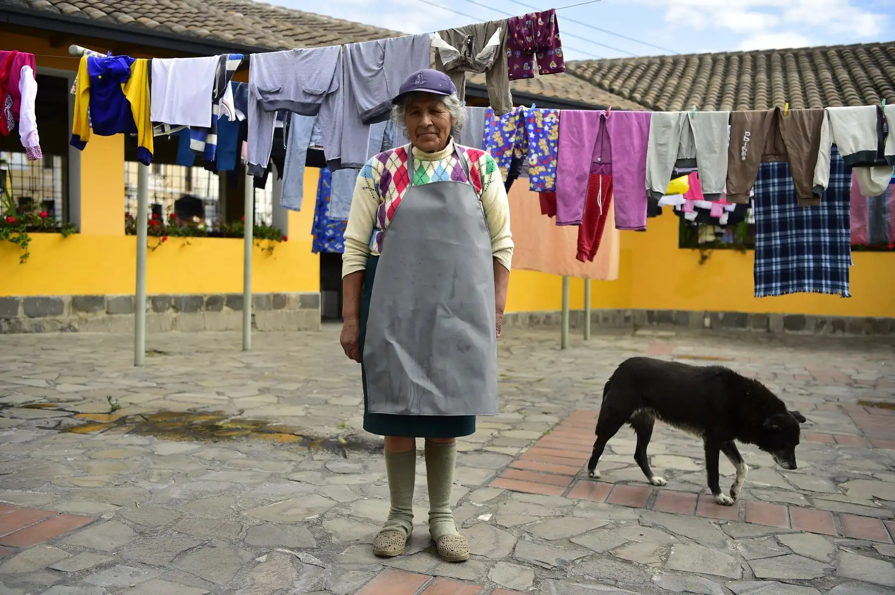 Lavandera ecuatoriana Delia Veloz, de 74 años, aparece junto a la ropa tendida en la lavandería municipal del barrio de Ermita, en Quito. Foto: AFP