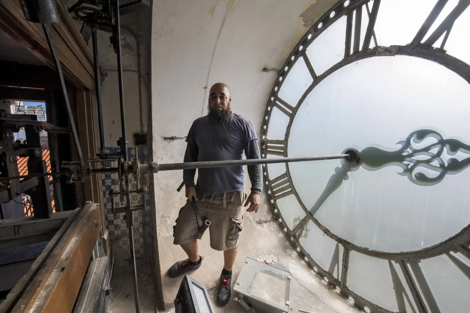 El relojero uruguayo Abdel Ghaffar posa junto al reloj de la Catedral de Montevideo. Foto: AFP