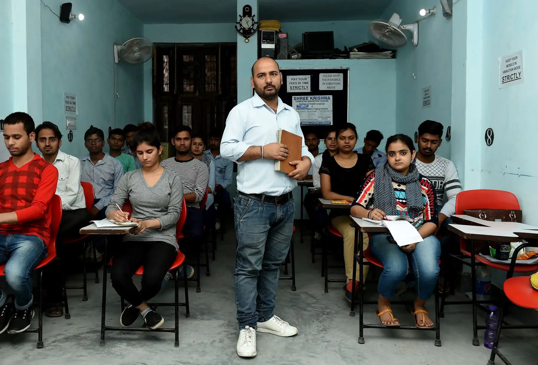 Surbir Singh, de 35 años, profesor de taquigrafía india, posa para una foto en un centro de taquigrafía rodeado de estudiantes en Faridabad. Foto: AFP