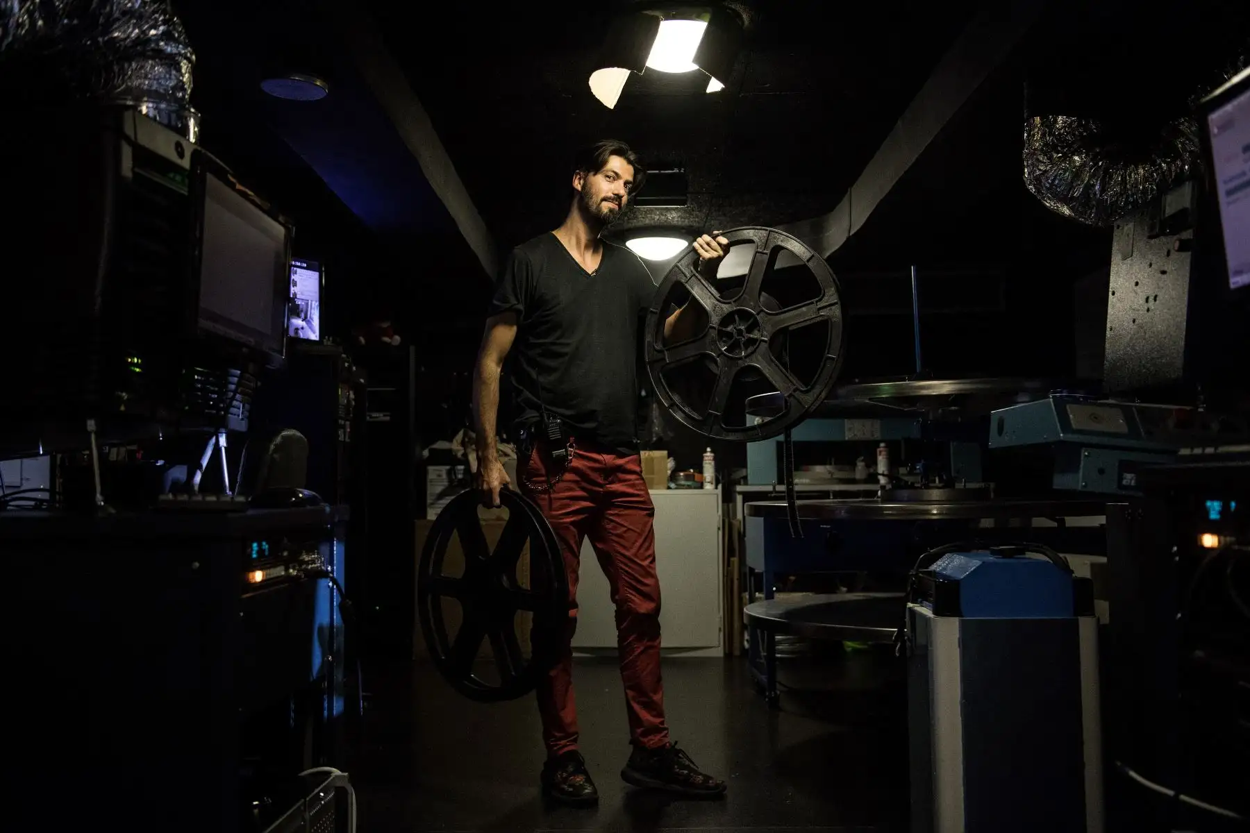 El proyeccionista francés Benjamin Louis posa para una fotografía con rollos de película en la sala de proyección del cine Louxor en París. Foto: AFP