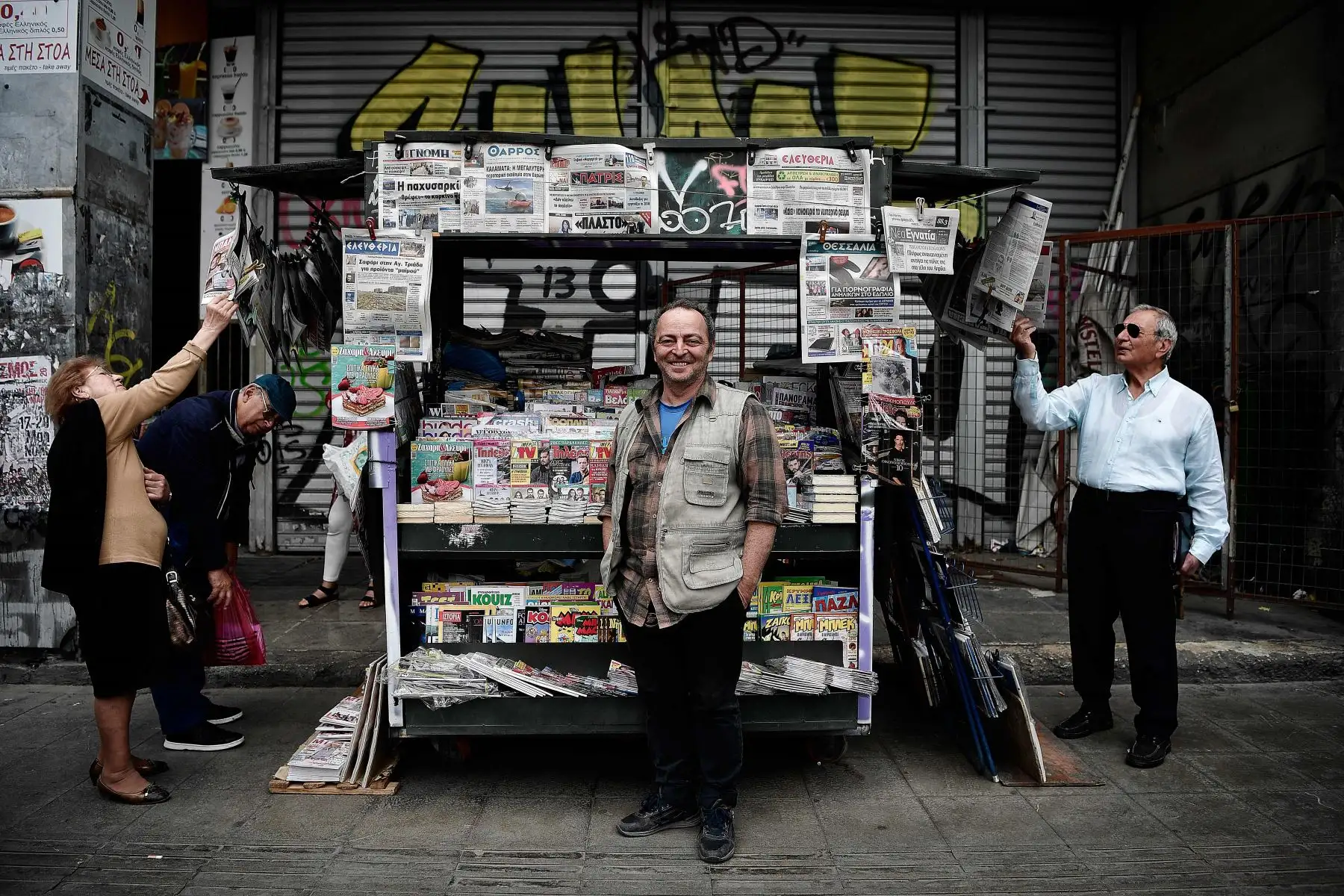 Kostas, posa frente a su stand en la plaza Omonia en el centro de Atenas. Foto: AFP