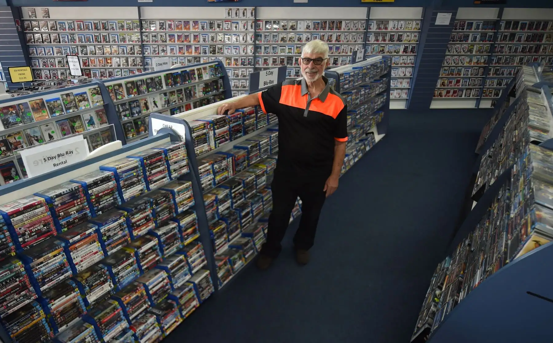 Geoffrey Hooper posa para una fotografía en su tienda de DVD en el suburbio occidental de Sydney, Mount Druitt. Foto: AFP