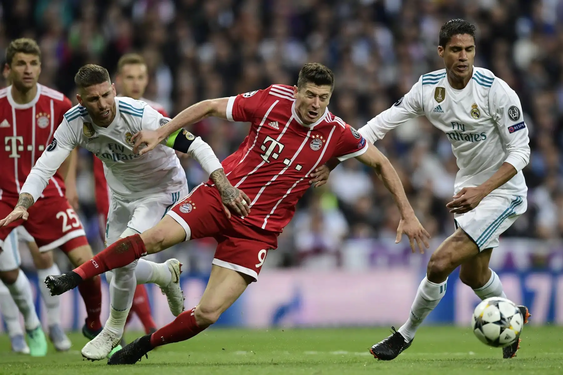 El delantero polaco del Bayern Múnich Robert Lewandowski compite con el defensa español Real Ramos y el defensor francés Real Madrid Raphael Varane durante el partido de vuelta de la semifinal de la UEFA Champions League. Foto: AFP.