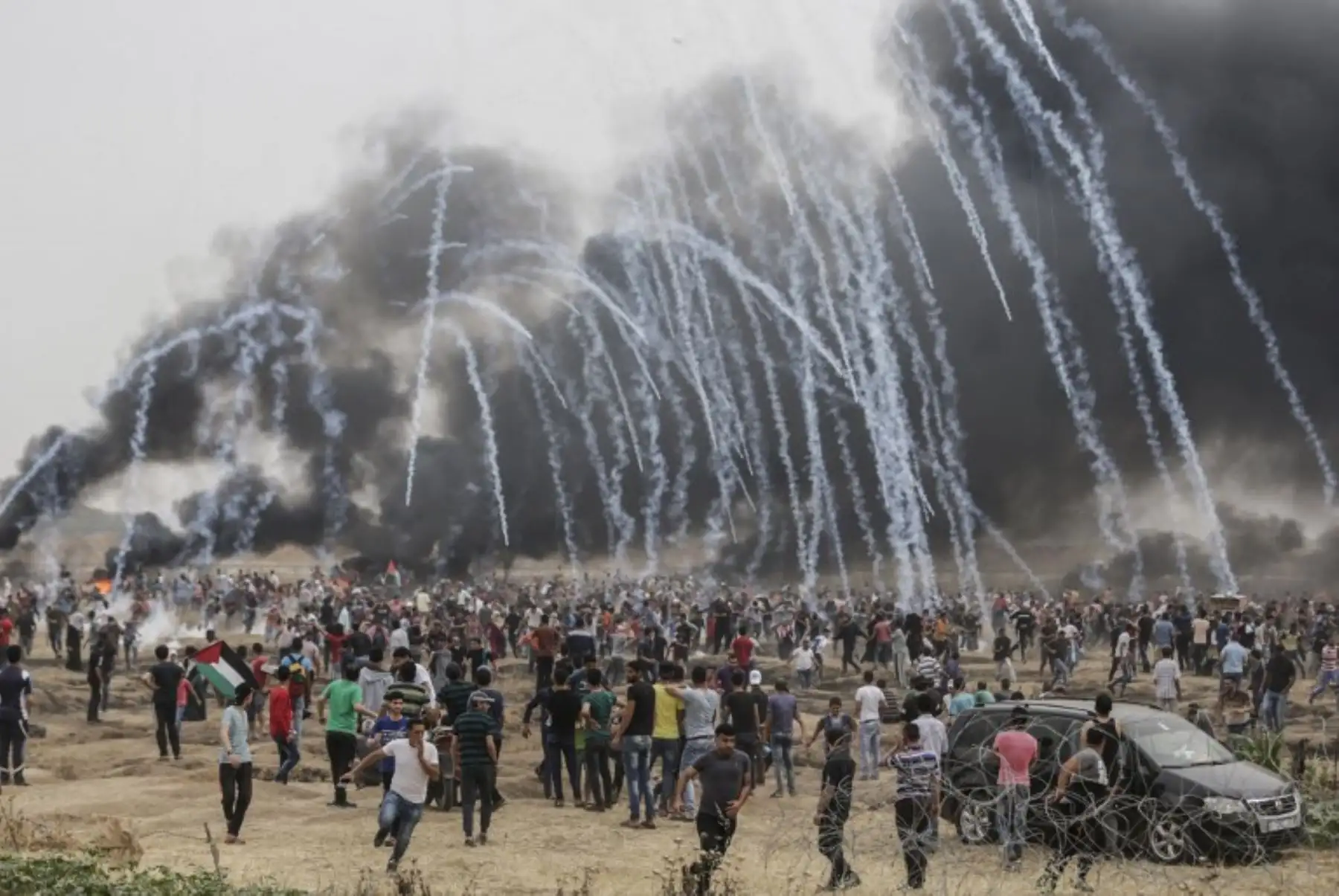 Manifestantes palestinos huyen de los  gases lacrimógenos durante los enfrentamientos con las fuerzas israelíes en la frontera con Gaza.Foto:AFP