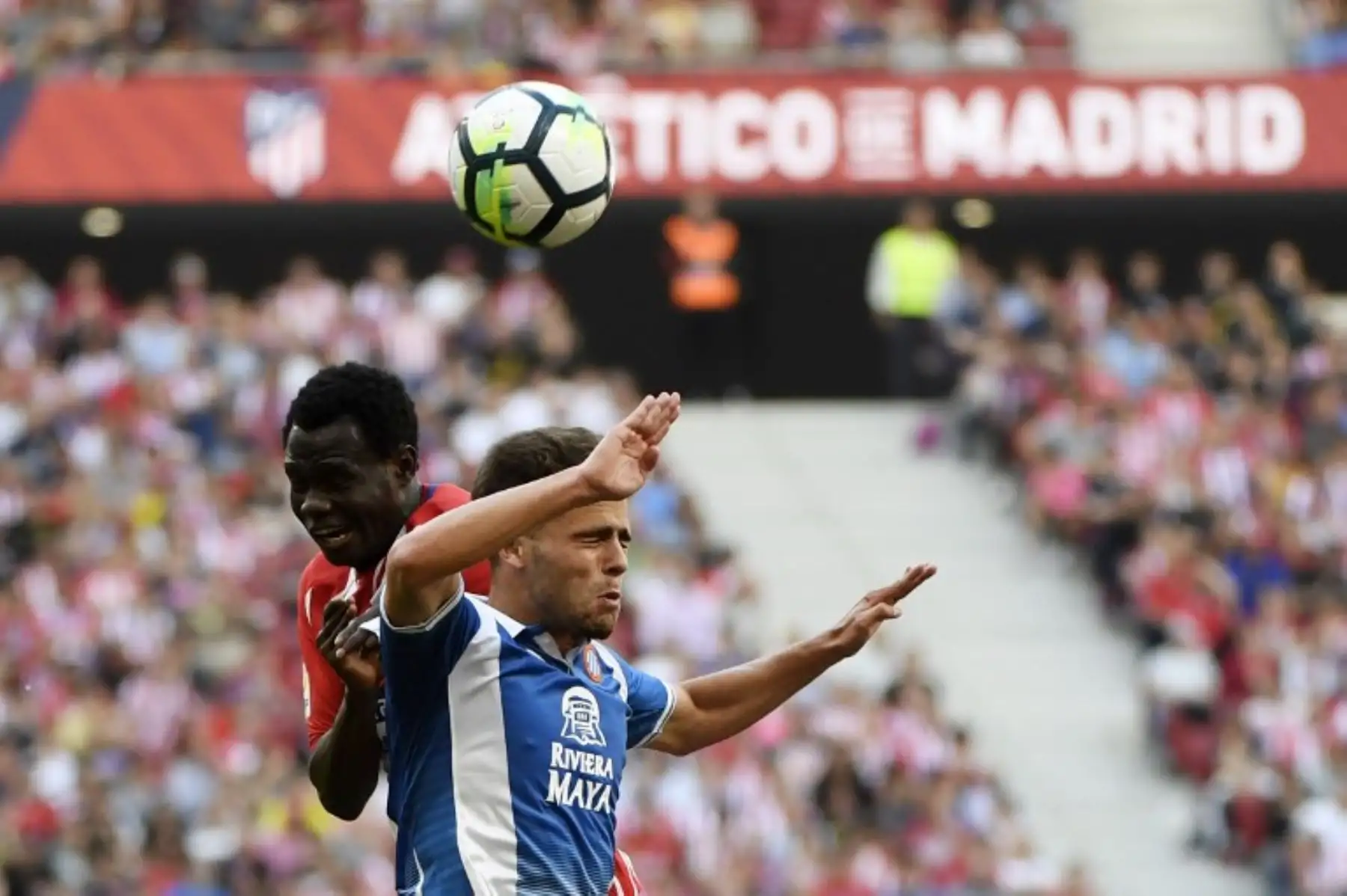 El centrocampista español del Espanyol Oscar Melendo encabeza la pelota con el defensa  del Atlético de Madrid Arona Sane durante el partido de fútbol de la liga española.Foto:AFP