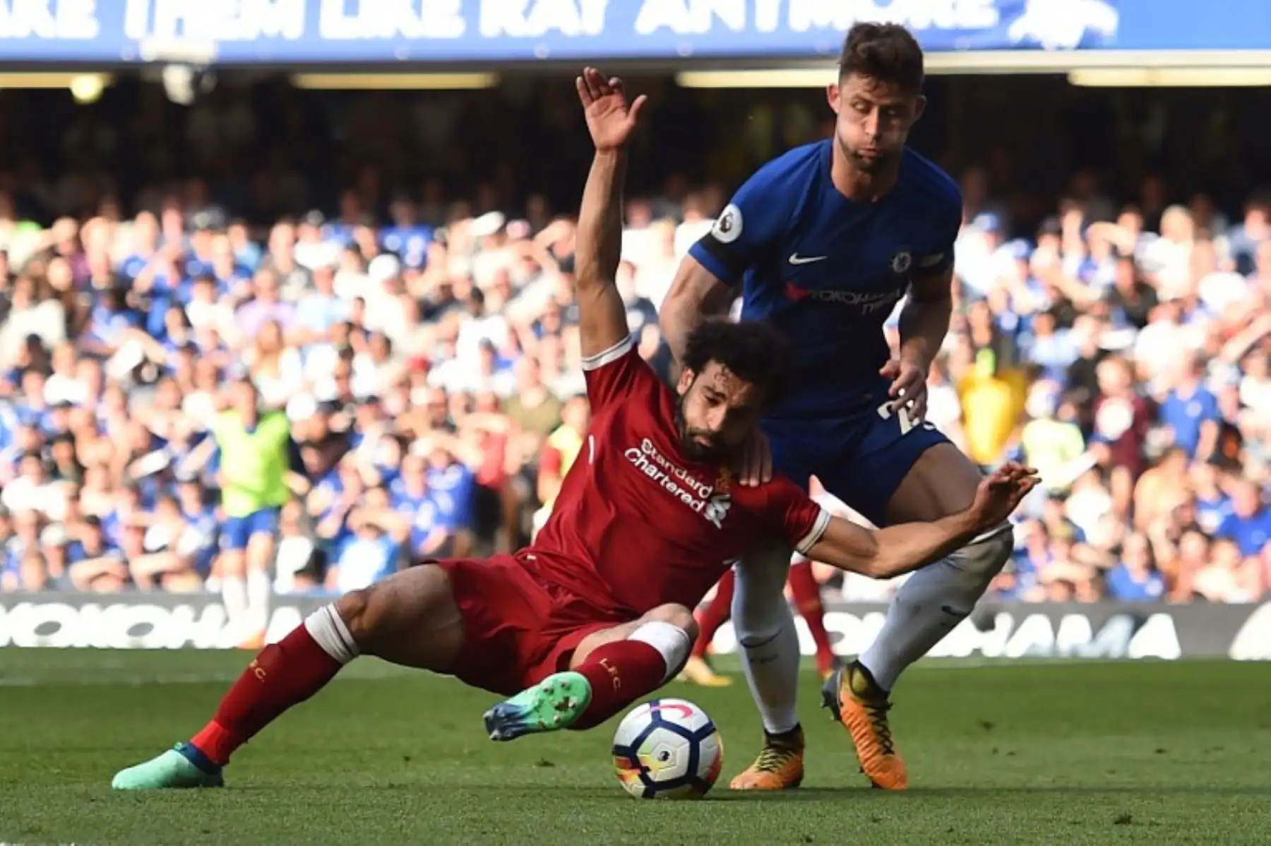 El mediocampista egipcio del Liverpool Mohamed Salah compite con el defensor inglés del Chelsea Gary Cahill, durante el partido de fútbol de la Liga Premier inglesa. Foto: AFP.