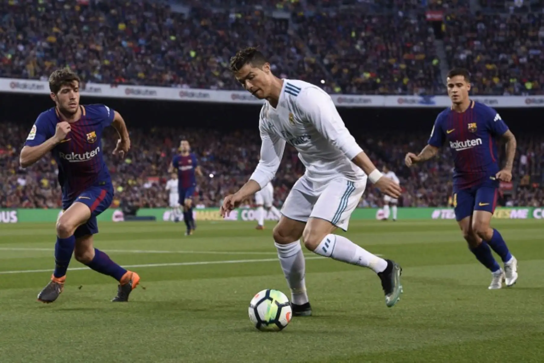 El delantero portugués del Real Madrid Cristiano Ronaldo,  desafía al mediocampista Sergi Roberto y al centrocampista brasileño del FC Barcelona Philippe Coutinho durante el partido de fútbol de la liga española.Foto:AFP