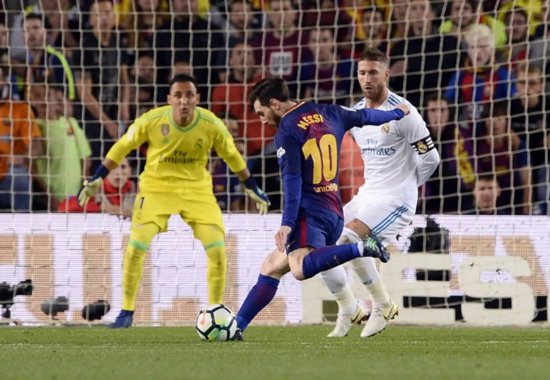 El delantero argentino Lionel Messi dispara para marcar un gol durante el partido de fútbol de la liga española entre el FC Barcelona y el Real Madrid CF.Foto:AFP