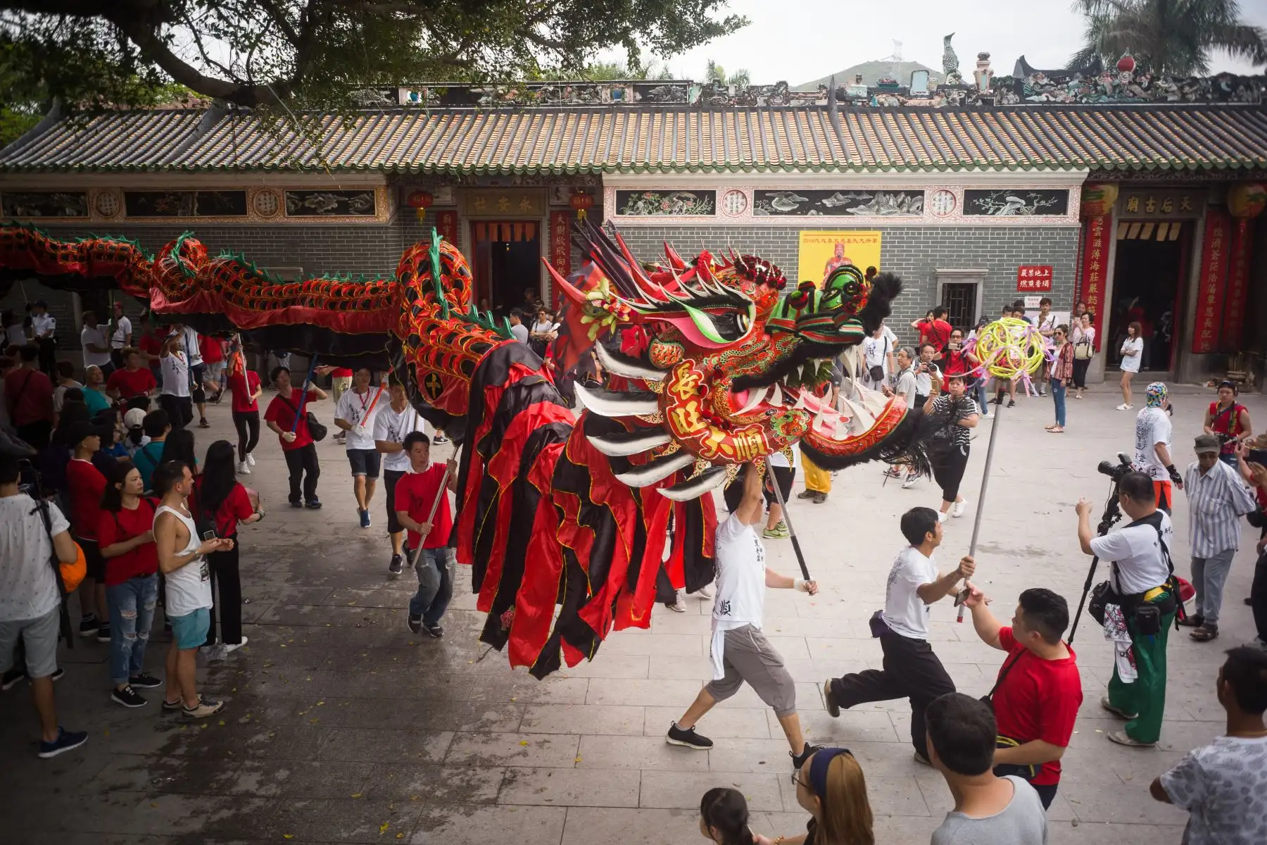 La gente mira a una compañía de danza de dragones actuar mientras celebran el Festival de Tin Hau en  Long de Hong. AFP