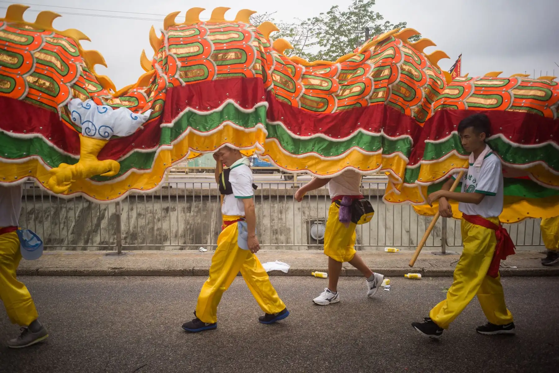 Los miembros de una compañía de danza del dragón caminan en una acera antes de actuar para celebrar el Festival de Tin Hau. AFP