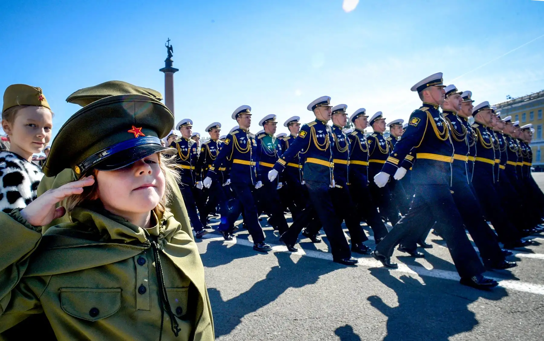 Una niña vestida con un uniforme del ejército soviético hizo un saludo  mientras el personal militar ruso marcha en la plaza Dvortsovaya durante el desfile militar del Día de la Victoria en San Petersburgo. AFP